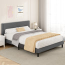 Gray upholstered bed with beige blanket in a bedroom setting