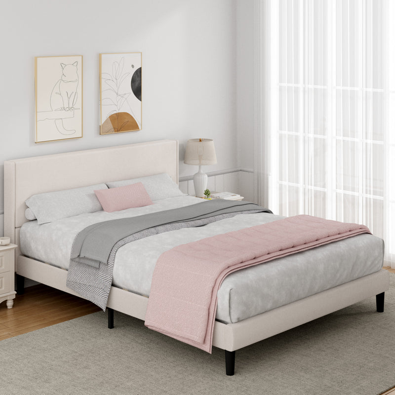 Neatly made bed with pink and gray bedding in a bedroom setting.